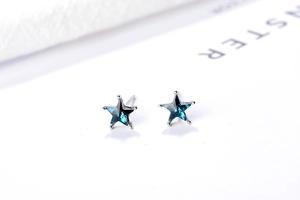 Vue macro de boucles d'oreilles étoile en argent S925 avec pierres bleues facettées
