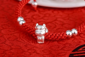 Detailed view of S999 silver ox pendant on hand-woven red rope zodiac bracelet