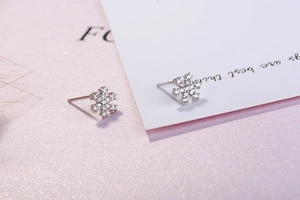 Vue macro des boucles d'oreilles flocon en argent S925 avec zircons sur fond violet
