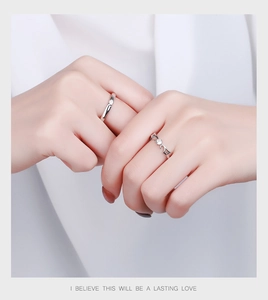 Close-up of S925 silver angel wing couple rings with zircon stones worn by a model