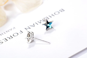 Gros plan de boucles d'oreilles étoile en argent S925 avec zircons bleus sur carte