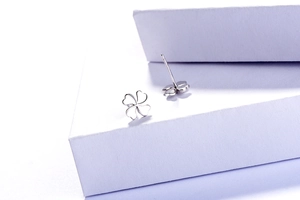 Gros plan détaillé des boucles d'oreilles trèfle à quatre feuilles en argent S925 sur socle