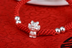 Close-up of S999 silver dragon pendant and red woven rope with detailed metalwork