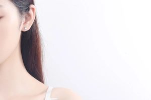 Detailed view of an S925 silver elk antler earring with a heart-shaped crystal on an ear