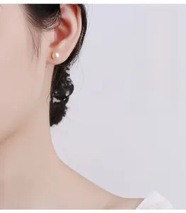 Side view of a 6-8mm pink-white pearl stud earring worn on a model's ear