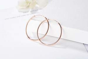 Vue détaillée de grandes boucles d'oreilles créoles en argent S925 plaqué or rose poli