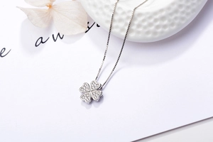 Vue macro d'un pendentif trèfle en argent 925 serti de pierres scintillantes sur chaîne