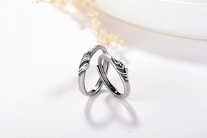 Gros plan de bagues de couple en argent S925 avec textures gravées vintage de mont et mer