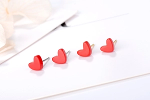 Close-up of S925 sterling silver red heart stud earrings with glossy enamel finish