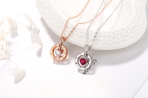 Gros plan de pendentifs en forme de cœur en or rose et argent avec pierres précieuses