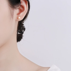 Elegant S999 sterling silver stud earrings with 8mm round cream pearl on ear lobe
