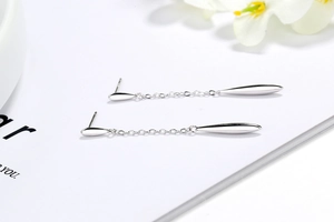 Macro detail of S925 sterling silver drop earrings with elegant long chain fringe tassels