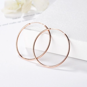 Élégantes créoles en argent sterling S925 doré rose sur une boîte d'exposition blanche