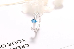 Details des silbernen Astrings mit einem blauen Edelstein im Birnenschliff