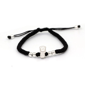 Detailed macro of handmade black braided rope bracelet with S999 silver zodiac pendant