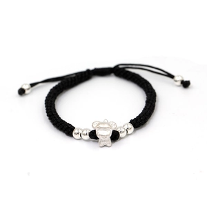 Detail of hand-woven black cord bracelet with silver zodiac charm and adjustable beads