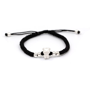 Macro detail of hand-woven black cord bracelet with silver Chinese zodiac pig charm