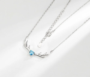 Detail view of S925 sterling silver deer antler necklace with blue heart crystal pendant