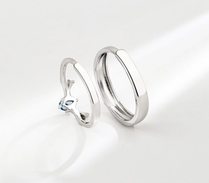 Dettaglio macro degli anelli di coppia in argento con corna e pietra blu a goccia