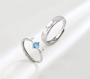 Dettaglio anelli di coppia in argento con corna di cervo e gemma blu, misura regolabile