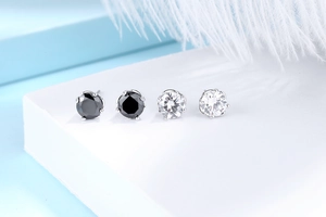 Detail view of S925 sterling silver four-claw stud earrings with black and white zircons