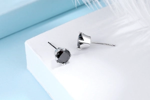 Close-up of S925 sterling silver stud earrings featuring black round-cut zirconia settings