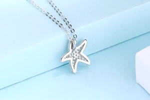 Vue macro du pendentif étoile de mer en argent montrant la structure creuse détaillée