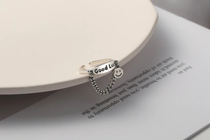 Detail of S925 silver Good Luck ring with hanging smiley face charm and chain