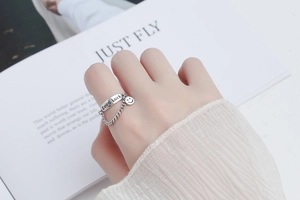 Detail of 925 silver Good Luck ring with chain linked smiley face charm on hand