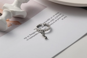 Detailed view of s925 silver ring featuring woven chain texture and a unique human charm