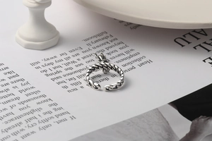 Close-up of vintage S925 silver woven ring with a small dragon pendant detail