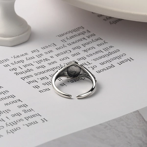 Vintage 925 sterling silver open ring with black round inlay on artistic book background