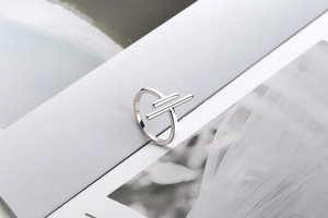 Detail of minimalist S925 sterling silver hollow ring placed on magazine pages