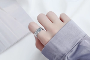 Detail of vintage irregular silver rings on a purple silk sleeve with industrial style