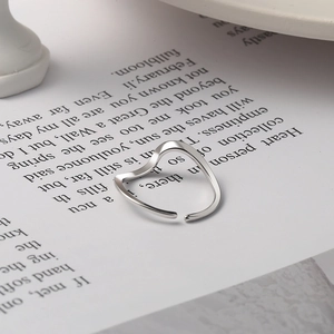 Minimalist 925 sterling silver Mobius ring with sleek wave heart shape on vintage paper