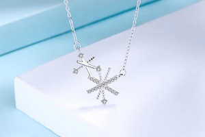 Vue macro d'un collier tournesol en argent S925 avec zircons pavés sur fond bleu ciel