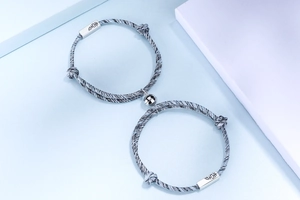 Detalle de pulseras magnéticas para parejas de plata S925 con cuerda trenzada y dije grabado