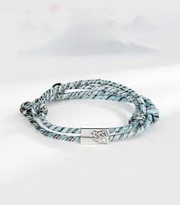 Detail of woven couple bracelets with magnetic silver clasp showing mountain and sea relief