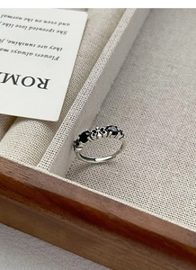 Macro detail of vintage S925 sterling silver ring with black stones and cross engraving