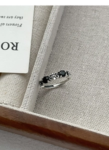 Close-up of vintage S925 sterling silver ring with three black gemstones and gothic patterns