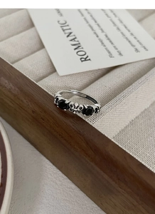 Macro shot of S925 sterling silver ring showing internal hallmark and black gemstones