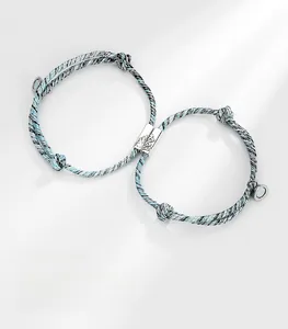 Detail of mountain and sea relief on magnetic charms of woven couple bracelets