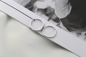 Close-up of s925 silver couple rings featuring a red heart on a fashion magazine