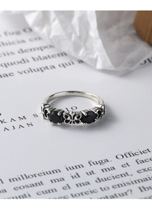 Macro shot of retro S925 silver ring featuring butterfly motif and black gemstones