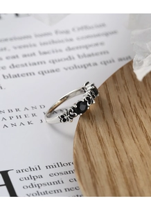 Macro detail of retro s925 silver ring featuring black zircon stones and gothic heart pattern