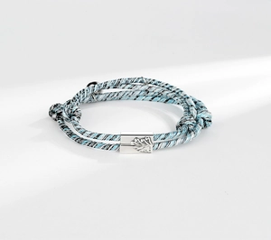 Detail of hand-woven magnetic couple bracelets with intricate feather engraved buckles