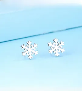 Vue détaillée des boucles d'oreilles flocon de neige en argent sterling S925 poli sur bleu