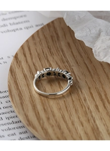 Macro detail of S925 sterling silver ring with black gemstones and hollow carving