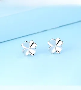 Macro view of minimalist S925 sterling silver four-leaf clover stud earrings for women