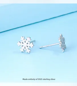 Gros plan de boucles d'oreilles flocon en argent sterling S925 avec poinçon argent gravé